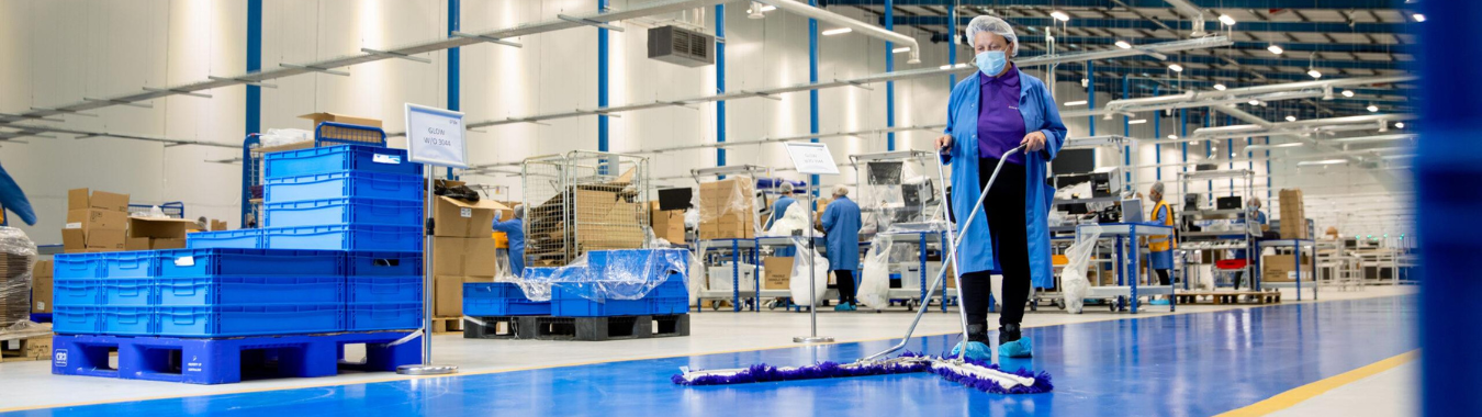 Factory cleaners in a factory using tools to perform industrial cleaning as industrial cleaners